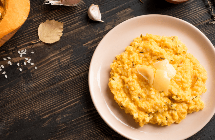Table top with ingredients for pumpkin risotto next to a bowl of fully cooked pumpkin risotto